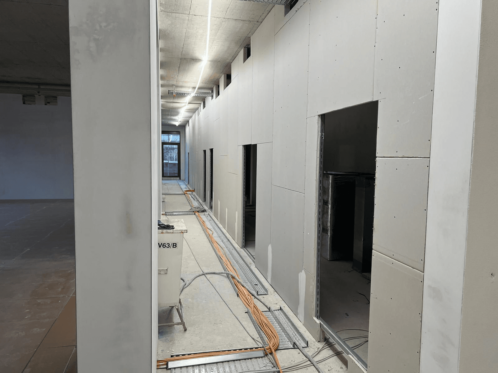 Büroraum im Rohbau mit Sichtbeton und Lüftungsrohren
